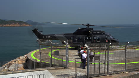 Paciente-Y-Cuidador-Abordando-Un-Helicóptero-De-Rescate-Del-Servicio-Médico-Del-Gobierno-De-Hong-Kong-En-El-Helipuerto-De-Cheung-Chau