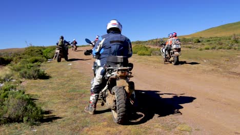 Motociclistas-Todoterreno-Partiendo-Por-Un-Camino-De-Ripio