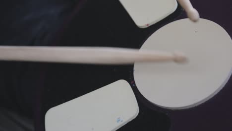 A-Beginner-Practicing-Drumming-By-Slowly-Striking-The-Drumhead-In-Tempo---Close-Up-Shot