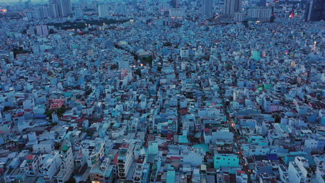 drone-shot-flying-straight-ahead-at-twilight-over-densely-populated-and-built-up-area-of-a-modern-asian-city