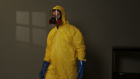 Hazmat-suit-wearing-man-explores-a-smoky-room