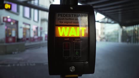 A-close-up-shot-of-a-Pedestrian-crossing-machine-being-pressed-by-a-black-male-with-the-wait-sign-illuminated