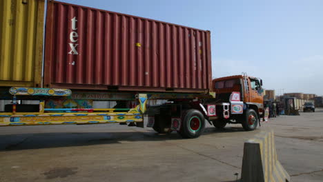 Eine-Nahaufnahme-Eines-Langen-Fahrzeugs,-Das-Mit-Seinem-Container-Von-Der-Kamera-Am-Hafen-Vorbeifährt