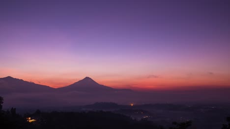 Mount-Merapi-Sonnenaufgang-Mit-Violettem-Himmel,-Weiten-Wolken-Und-Wirbelndem-Nebel
