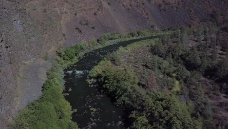 Drone-flying-in-a-canyon-following-a-river-upstream-to-reveal-a-waterfall-in-Lassen-county-in-Northern-California-in-the-fall