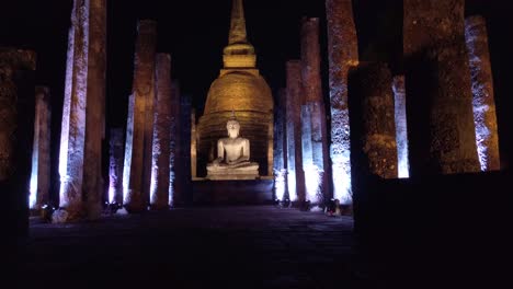 TILT-UP:-sukhothai-historical-park-thailand-buddha-sculpture-illuminated-at-night-pan