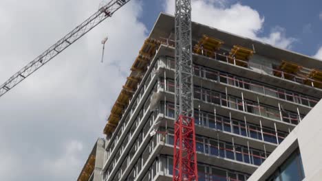 Tilt-down-shot-of-a-apartament's-building-under-works-with-a-big-crane