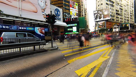 Zeitraffer---Fußgängerüberweg-Auf-Der-Insel-Hongkong,-Busse-Und-Hohe-Gebäude,-Bewegungsunschärfe-Beim-Verlassen-Von-Spuren