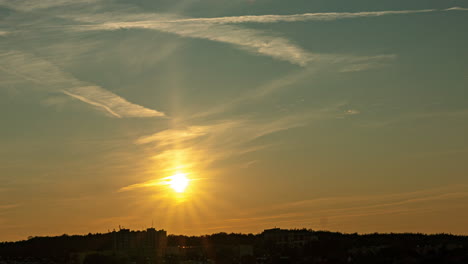Ein-Wunderschöner-Sonnenuntergang,-Wenn-Die-Sonne-Untergeht,-Ein-Magischer-Himmel-Mit-Leichten-Wolken-Und-Einer-Spur-Des-Flugzeugs,-Kleine-Bewegung-Der-Ernte