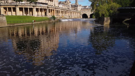Empire-Hotel,-Pulteney-Weir---Pulteney-Bridge-in-Bath,-Somerset-on-a-Beautiful-Summer’s-Morning-fading-out-towards-the-River-Avon