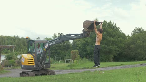 Healthy-fit-young-man-topless-using-digger-for-pull-up-exercises