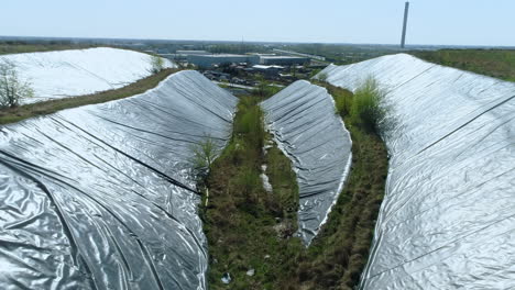 Aerial-view-of-the-sides-of-garbage-dump-hill-covered-with-protective-film