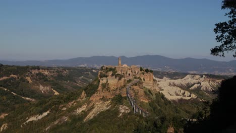 Static-wide-shoot-for-the-dying-town-Civita-di-Bagnoregio-in-Italy-on-top-of-the-mountain-with-a-walking-bridge-full-of-tourists