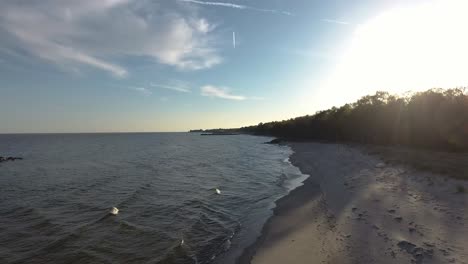 Wunderschöne-Luftaufnahme-Des-Saltsjöbad-Strands-Von-Ystad-Bei-Sonnenuntergang-In-Südschweden-In-Der-Nähe-Des-Ozeans-Östersjön-Mit-Einem-Fliegenden-Vogel