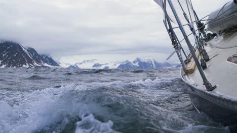Sailing-a-yacht-in-the-high-Arctic-seas-in-Svalbard---Slow-motion-shot-waves-crashing-along-hull