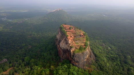 Distant-aerial-drone-shot-of-Sigiriya-Rock,-Sri-Lanka