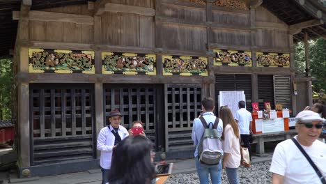 Turistas-Tomando-Fotos-De-La-Famosa-Talla-Restaurada-De-Los-Tres-Monos-En-Los-Establos,-Ubicados-En-El-Sitio-Del-Templo-Del-Santuario-Toshogu