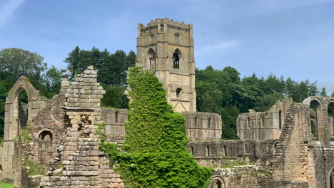 Statische-Aufnahme-Der-Ruinen-Eines-Zisterzienserklosters-Im-Norden-Von-Yorkshire-An-Einem-Wunderschönen-Sommertag-Mit-Bäumen,-Die-Im-Wind-Wehen