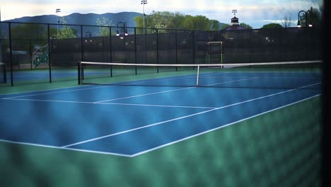 A-smooth-shot-from-outside-the-fence-looking-in-on-an-empty-tennis-court