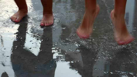 Siblings-Children-happy-wet-feet-jumping-in-slow-motion-on-water-puddle,-barefoot-child´s-play-outdoor-fun---games-childhood-siluete-reflections-infant-toddler-kids-H2O-90fps-120fps