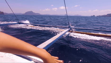 Female-arm-waving-like-the-crystal-clear-deep-blue-ocean-in-El-Nido,-Philippines,-on-a-wonderful-and-unique-boat-day-trip,-dreamlike-holiday-and-vacation