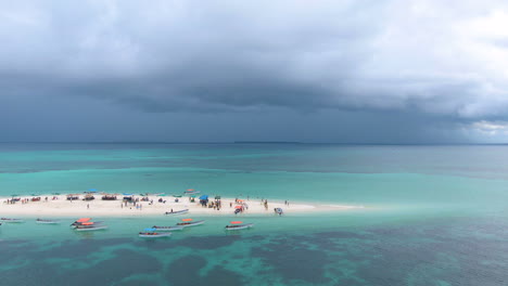 Dunkle-Wolken-über-Einer-Tropischen-Sandinsel-Mit-Menschen-Und-Booten