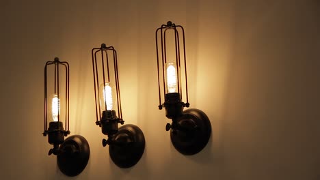 Tres-Lámparas-De-Pared-LED-Industriales-Amarillas-De-3200k-En-Una-Pared-Blanca---Diseño-Industrial---Escena-Oscura-De-Color-Negro