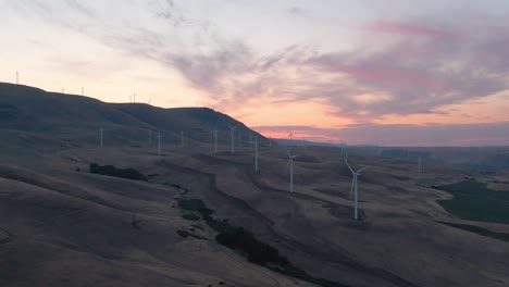 Beautiful-Aerial-Landscape-View-of-Wind-Turbines-on-a-Windy-Hill-during-a-colorful-sunrise