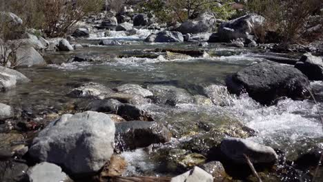 Half-speed-of-clear-water-flowing-through-rocks-in-a-creek-in-southern-California