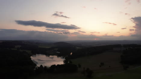 Rising-Aerial-Shot-of-a-Country-Estate-and-Lake-during-Sunset