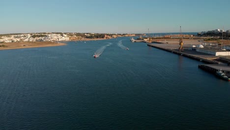 Aerial-of-fast-approaching-motor-boats-on-Arade-River-in-Algarve,-Portugal