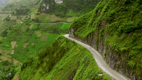 Folgende-Aufnahme-Eines-Motorrads,-Das-Entlang-Der-Kurvenreichen-Straße-Fährt,-Die-In-Den-Berghang-Des-Ma-Pi-Leng-Passes-Im-Norden-Vietnams-Eingeschnitten-Ist