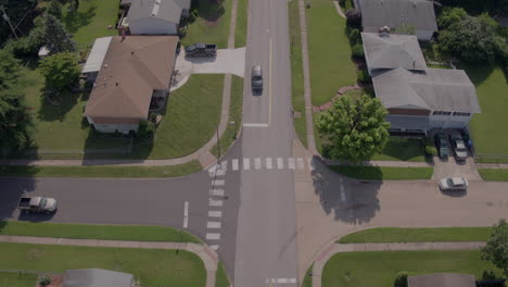 Push-up-a-quiet-suburban-street-with-cars-stopping-at-intersection