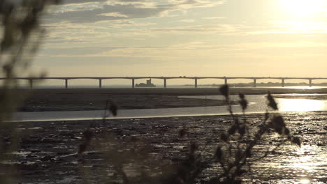 Car-traffic,-Bridge-to-the-island-d'Oleron-at-sunrise-from-mainland,-Fort-Louvois-Behind,-Nouvelle-Aquitaine,-France