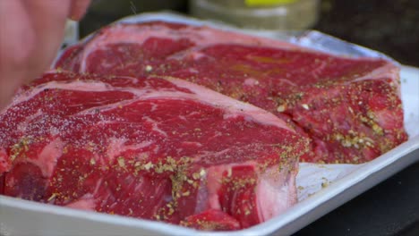 Eine-Hand-Gießt-In-Zeitlupe-Salz-über-Ein-Rib-Eye-Steak