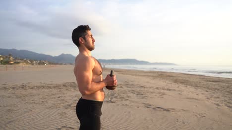 athlete-training-on-the-beach-with-kettlebell-and-sea-view