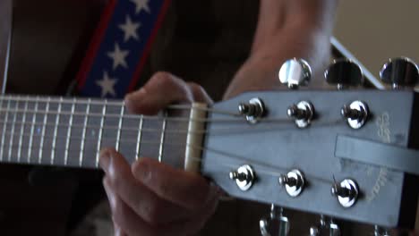Close-up-of-an-acoustic-guitar-being-strummed-by-a-female-band-member