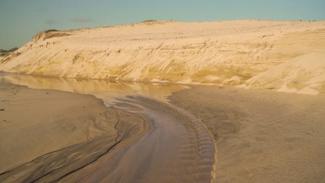 4K-coastal-sand-erosion-on-beach-after-heavy-rain-as-water-carved-her-way-Into-the-ocean
