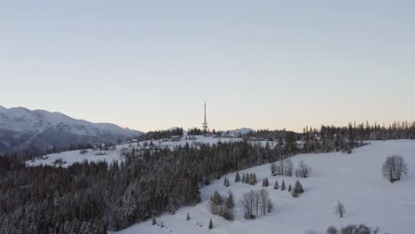 Zakopane-Gubalowka-Transmitter-Tower-With-Dense-Forest-And-Snowy-Gubalowka-Mountain-At-Zakopane,-Poland