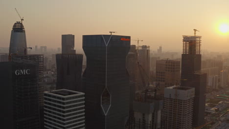 Slow-aerial-push-in-on-central-Alibaba-group-office-building-at-office-building-construction-site-at-beautiful-golden-sunset