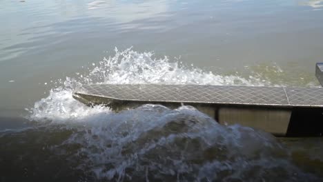Close-up-view-of-metal-canoe-outrigger-moving-through-water,-slow-motion