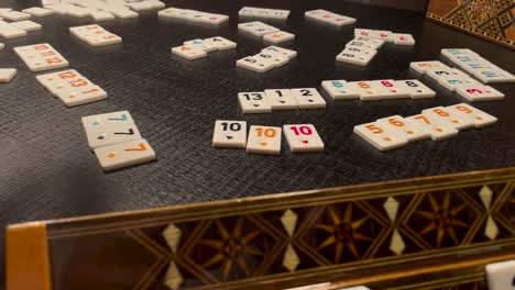 Woman's-Hand-Playing-Rummikub-Board-Game-On-The-Table