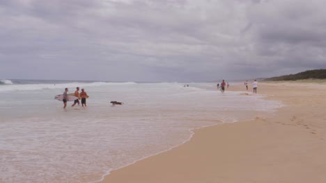 People-On-Splashing-Sea-Waves-Of-South-Gorge-Beach-In-Point-Lookout,-North-Stradbroke-Island,-Queensland-Australia