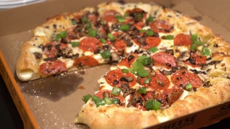 Handaufnahme-Einer-Person,-Die-Ein-Stück-Pizza-Aus-Einer-Pizzaschachtel-Zum-Mitnehmen-Mit-Gefülltem-Boden-Und-Peperoni-Pilzen-Und-Grünem-Pfeffer-Nimmt