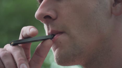 Close-Up-of-Male-Model-Smoking-Vaporizer-Outside-Slow-Motion