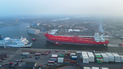 Aerial-drone-shot-of-gigantic-container-ship-leaving-the-port-of-Gdansk