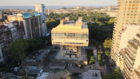 Aerial-lowering-on-Buenos-Aires-National-Library-of-brutalist-style-at-sunset-surrounded-by-buildings-and-trees