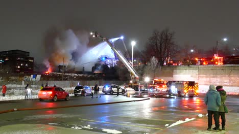 Riesiger-Hausbrand-In-Toronto,-Der-Von-Feuerwehrleuten-Bekämpft-Wird,-Die-Wasser-Von-Einer-Drehleiter-Versprühen