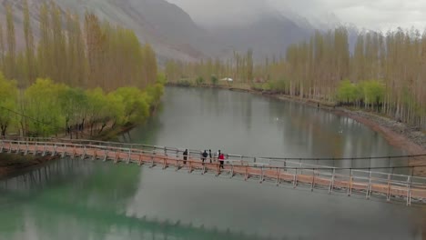 Luftaufnahme-Von-Menschen,-Die-Auf-Der-Holzbrücke-Phander-Nasser-über-Den-Fluss-Gilgit-Stehen