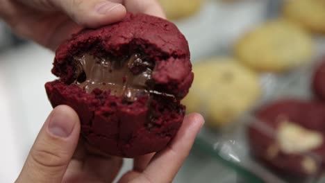 Breaking-open-a-freshly-backed-red-velvet-cookie-to-show-the-gooey-melted-chocolate-inside---close-up